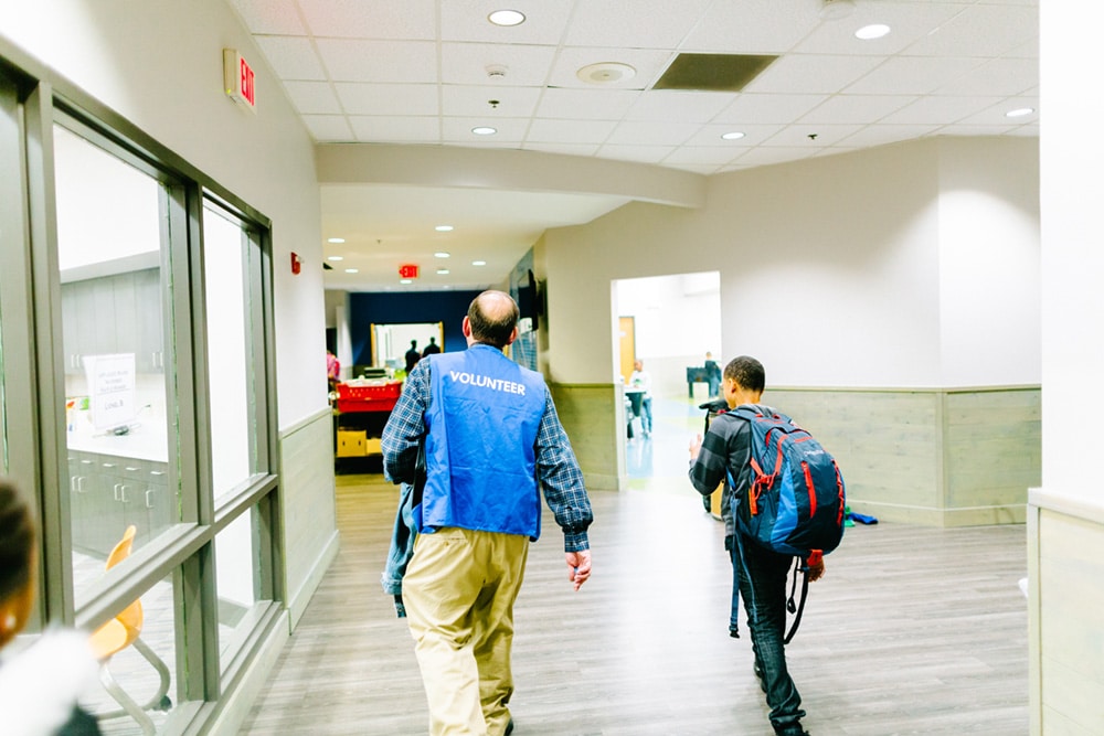 Club volunteer and teen with backpack