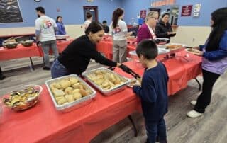 A Boys & Girls Club volunteer dishing up a child