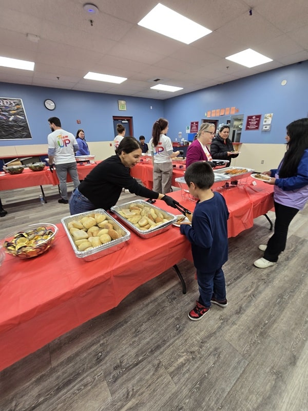 A Boys & Girls Club volunteer dishing up a child