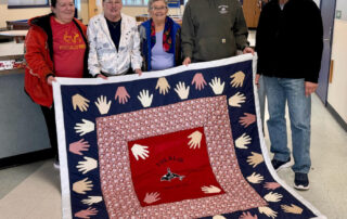 Jeanne McCoy with John McCoy quilt