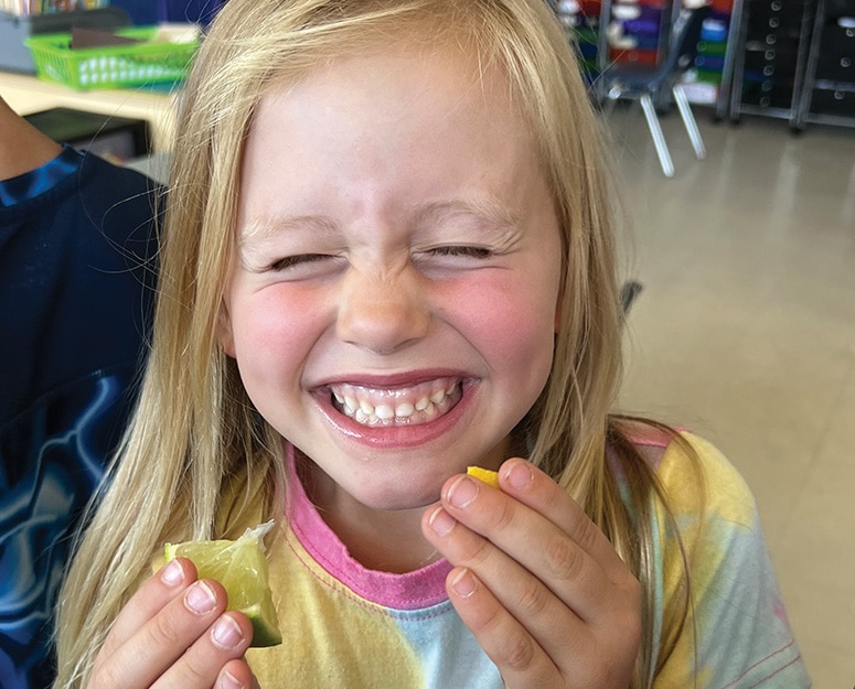 Brewster girl eating fruit and laughing
