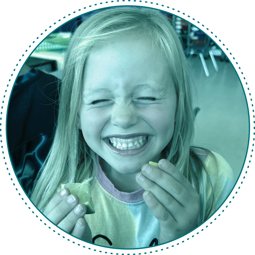 girl eating an orange and laughing