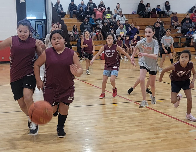 Lummi girls playing basketball in a gym