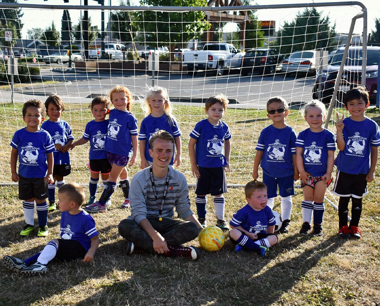 snohomish_sports Snohomish young kids soccer team with coach in front of goal net