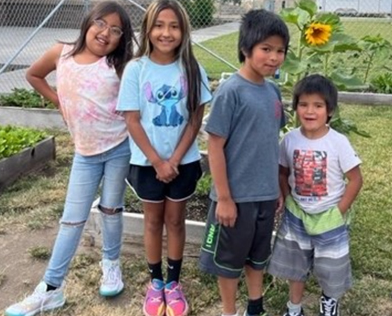 Warm Springs kids standing in a garden