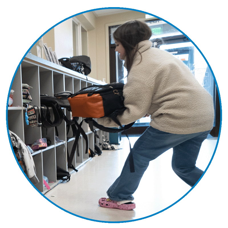 schoolsupply_circle_image_2 girl putting back pack in cubby at school