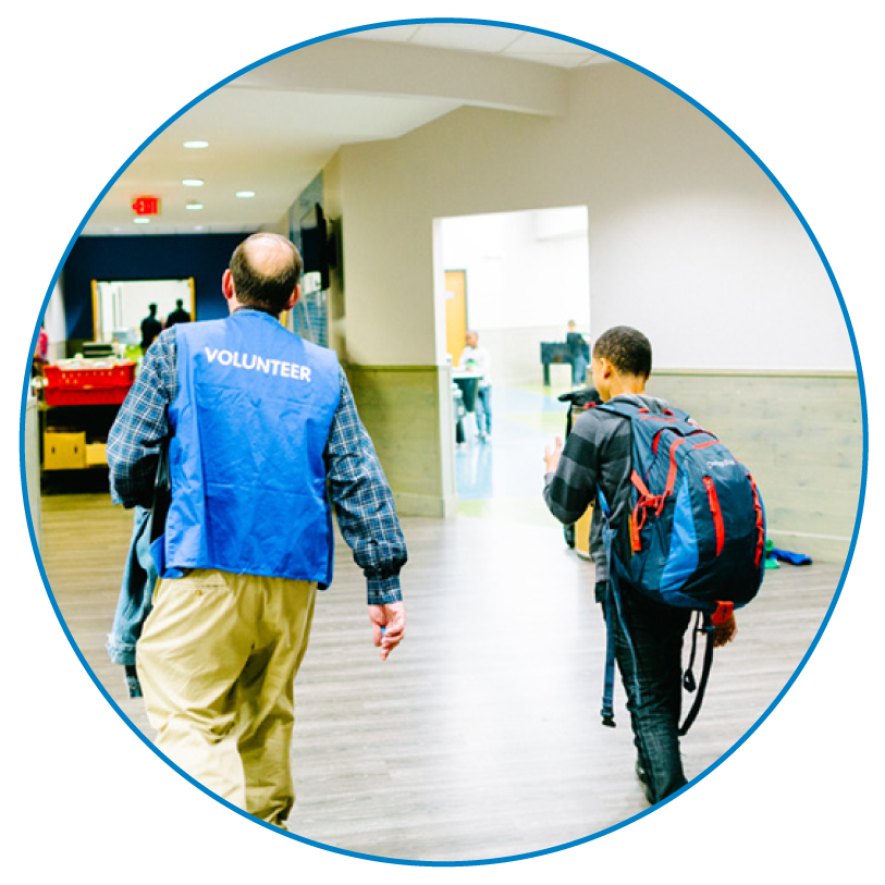 volunteer adult volunteer and club member walking down hallway