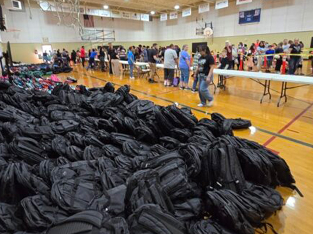 large pile of backpacks in gym