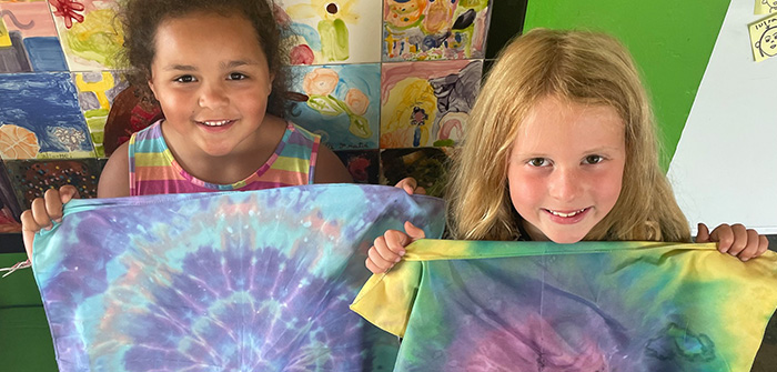 2 girls holding tie-dyed fabric