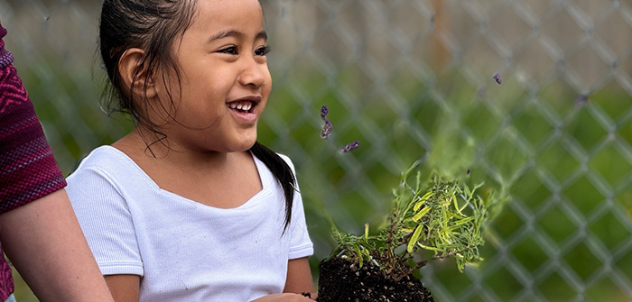 everett_popup_donation Smiling young girl holding seedling