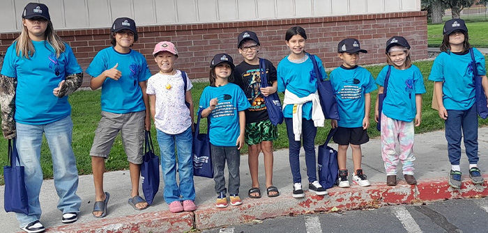 Kids standing outside Club in baseball hats and t-shirts