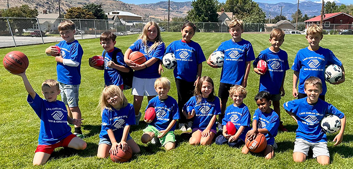 boys & girls standing and kneeling holding soccer balls