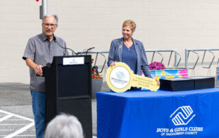 Bill Tsoukalas giving speech while Marci Volmer looks on