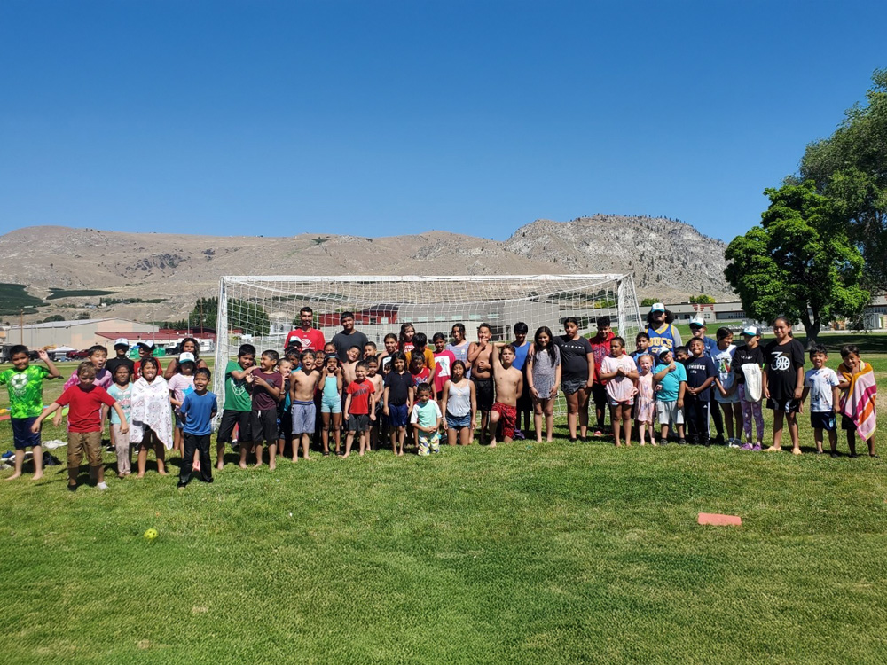 kids posing for picture on soccer field