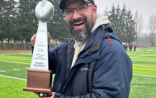 Coach Josh Peterson holding a trophy
