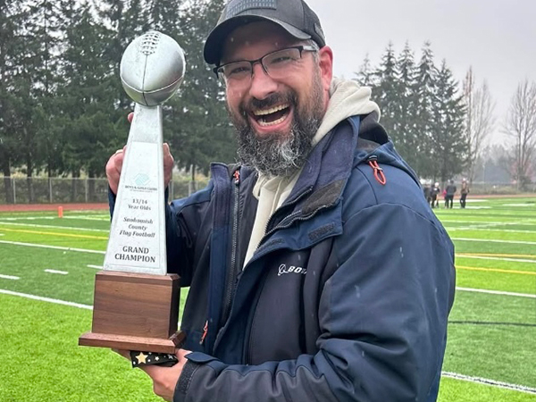 Coach Josh Peterson holding a trophy