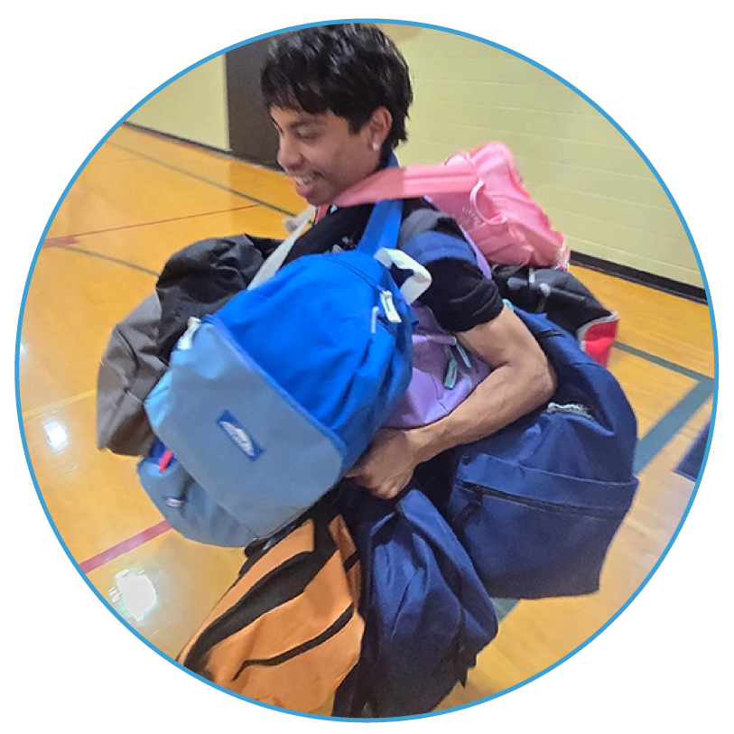 circle_image_2 boy with arms full of backpacks