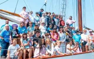 large group of kids and adults on deck of a ship