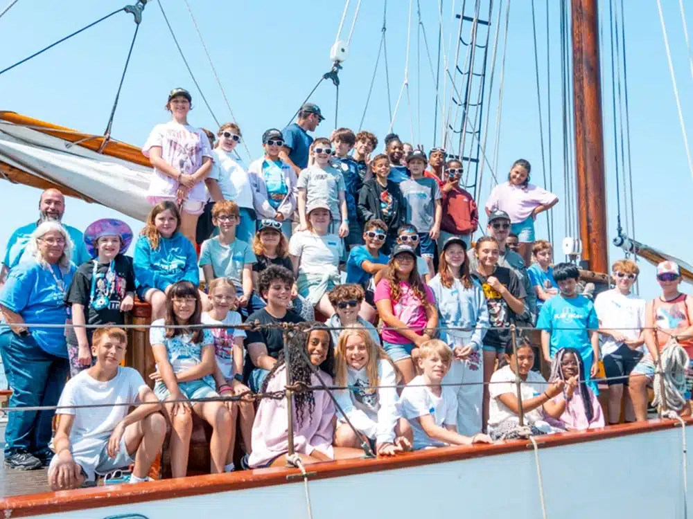 large group of kids and adults on deck of a ship